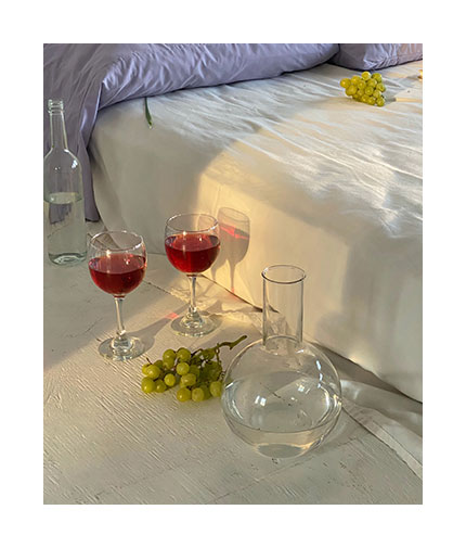 Deux verres de vins au bord d'un lit