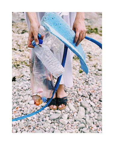 Ramassage de détritus en plastique sur une plage de galets