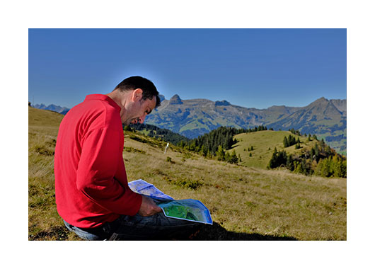 Un homme en montagne lisant une carte