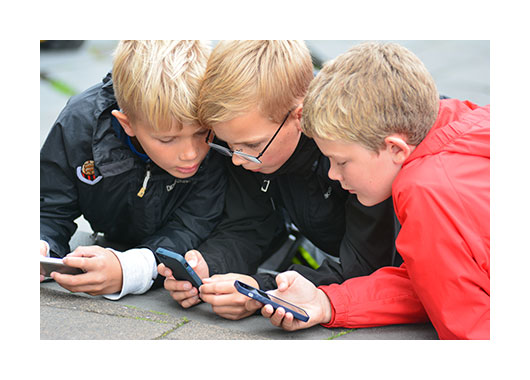 Trois enfants jouant avec des téléphones portables